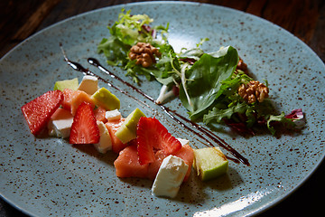 Image showing salad with strawberries, salmon, cheese and walnuts