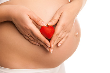 Image showing pregnant woman holding  heart symbol over white