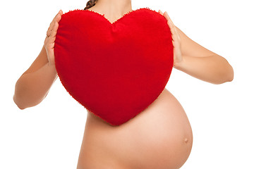 Image showing pregnant woman holding  heart symbol over white