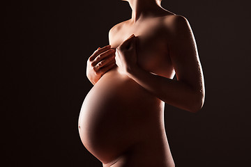 Image showing Pregnant woman silhouette over black background