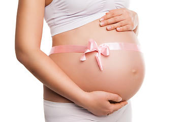 Image showing Pregnant woman tummy with pink ribbon over white