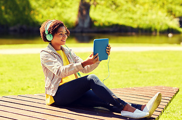 Image showing happy african woman with tablet pc and headphones