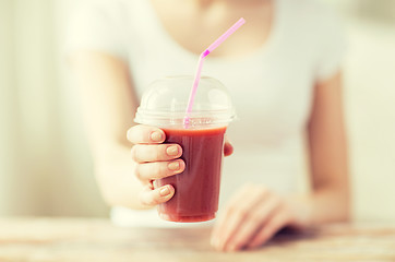 Image showing close up of woman holding cup with smoothie