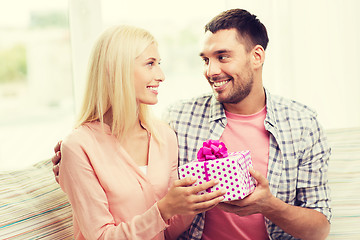 Image showing happy man giving woman gift box at home