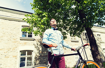 Image showing happy young hipster man riding fixed gear bike