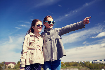 Image showing happy little girls hugging and pointing finger