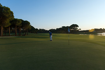 Image showing golfer hitting ball to hole