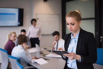 Image showing business woman working on tablet at meeting room