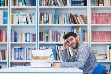 Image showing portrait of student while reading book  in school library