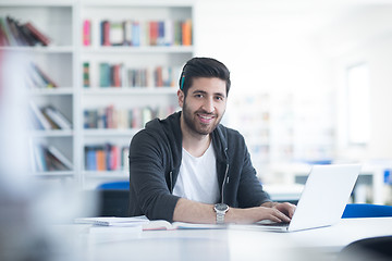 Image showing student in school library using laptop for research