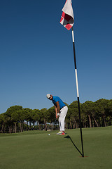 Image showing golf player hitting shot at sunny day