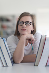 Image showing portrait of famale student selecting book to read in library