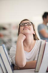 Image showing portrait of famale student selecting book to read in library