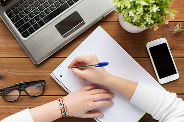 Image showing close up of woman or student writing to notepad