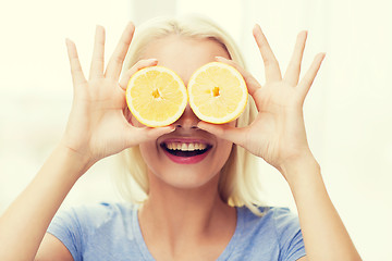 Image showing happy woman having fun covering eyes with lemon