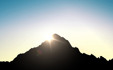 Image showing silhouette of mountain top over sky and sun light