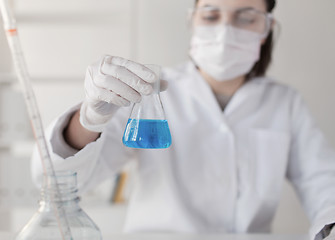 Image showing close up of woman with flask making test in lab