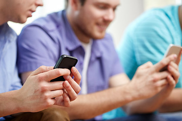 Image showing close up of happy friends with smartphones at home