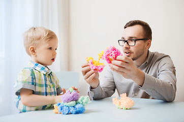 Image showing father and son playing with ball clay at home