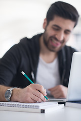 Image showing student in school library using laptop for research