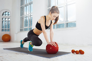 Image showing Beautiful slim brunette doing some gymnastics at the gym