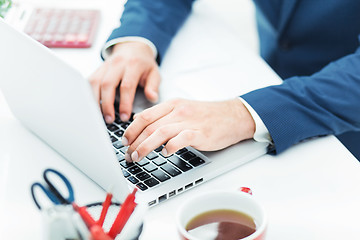 Image showing The male hands on the keyboard of laptop computer