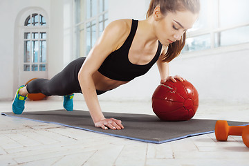 Image showing Beautiful slim brunette doing some gymnastics at the gym