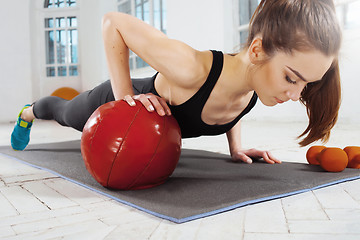 Image showing Beautiful slim brunette doing some gymnastics at the gym