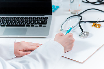 Image showing The hands of doctor woman writing at the medical office