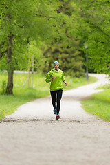 Image showing Sporty young female runner in city park.. 