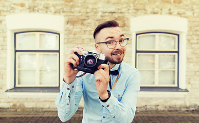 Image showing happy young hipster man with film camera in city