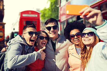 Image showing smiling friends taking selfie with smartphone