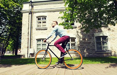 Image showing happy young hipster man riding fixed gear bike