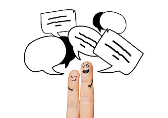 Image showing close up of two fingers with communication clouds