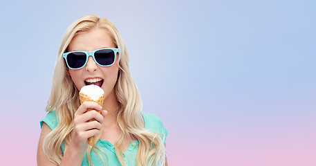 Image showing happy young woman in sunglasses eating ice cream