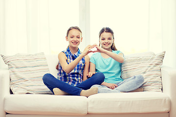 Image showing happy little girls showing heart shape hand sign