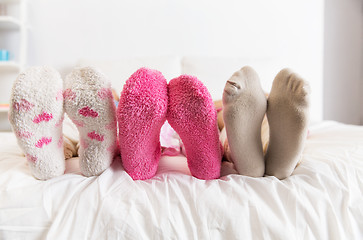 Image showing close up of women feet in socks on bed at home