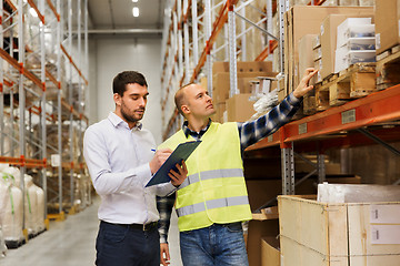 Image showing worker and businessmen with clipboard at warehouse