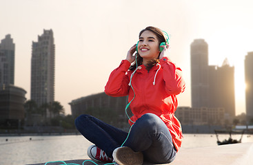Image showing happy young woman in headphones listening to music