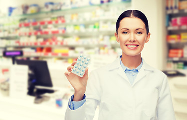 Image showing woman pharmacist with pills drugstore or pharmacy