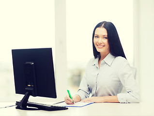 Image showing smiling businesswoman or student studying