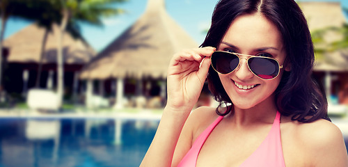 Image showing happy woman in sunglasses and swimsuit on beach