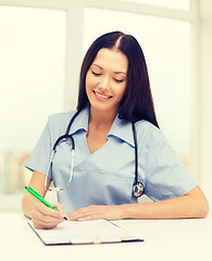 Image showing female doctor or nurse writing prescription