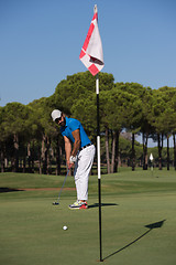 Image showing golf player hitting shot at sunny day