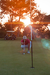 Image showing golf player aiming perfect  shot on beautiful sunset