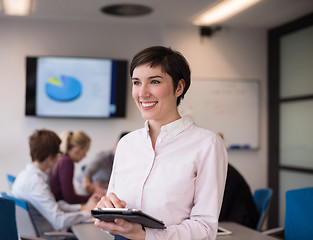 Image showing hispanic businesswoman with tablet at meeting room