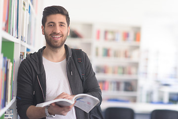 Image showing portrait of student while reading book  in school library