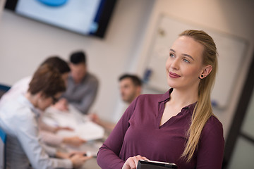 Image showing blonde businesswoman working on tablet at office