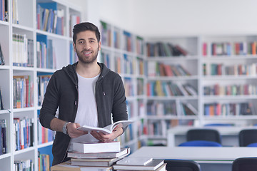 Image showing portrait of student while reading book  in school library