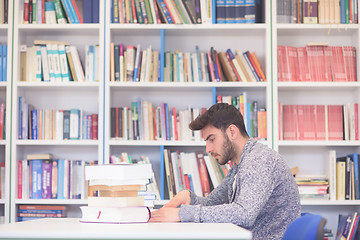 Image showing portrait of student while reading book  in school library